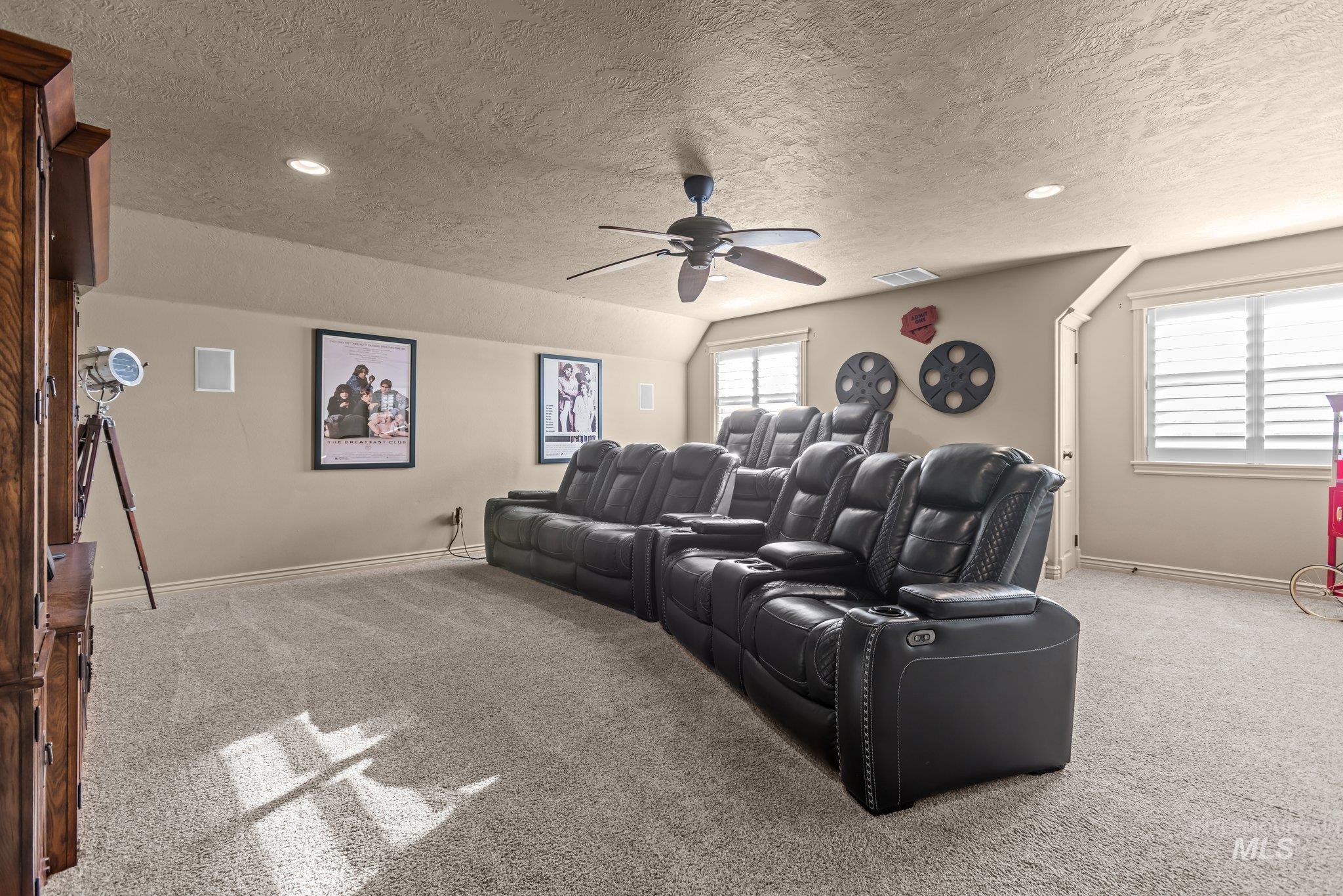 Home theater room with light carpet, a textured ceiling, ceiling fan, and recessed lighting