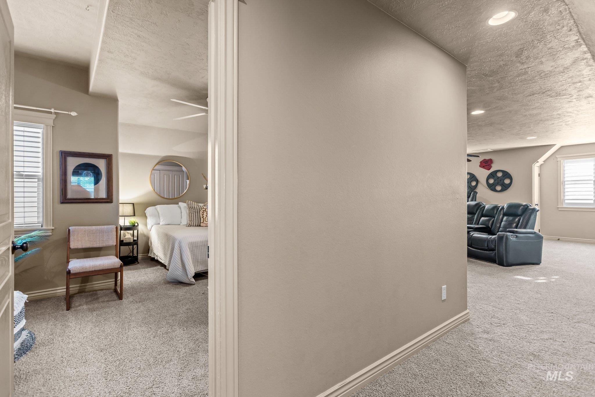 Hall with a textured ceiling and light carpet