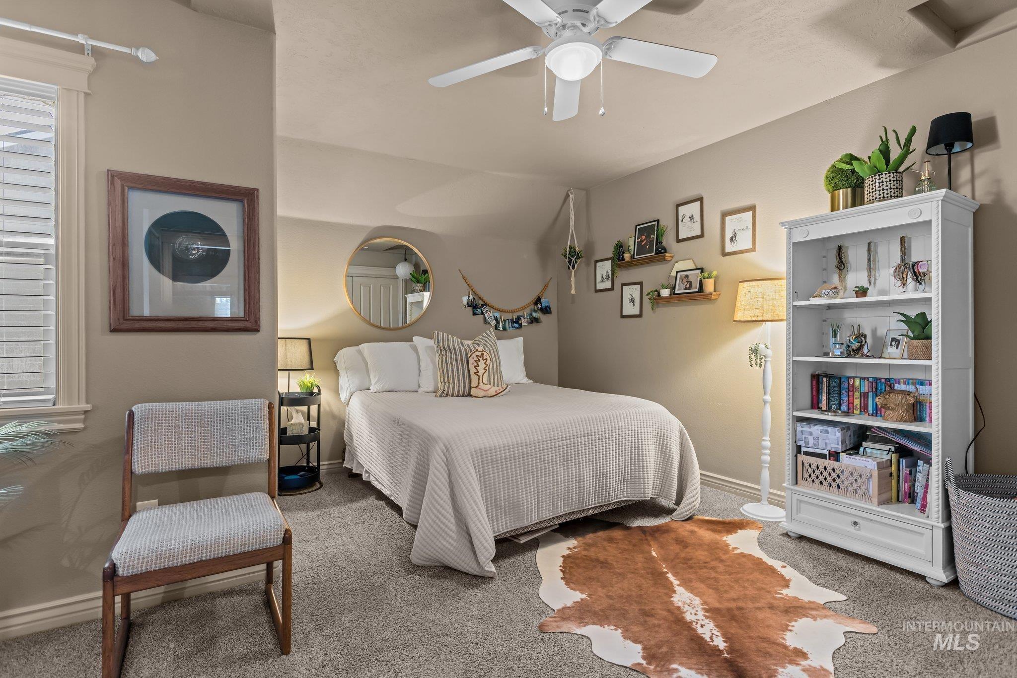 Carpeted bedroom featuring a ceiling fan and baseboards
