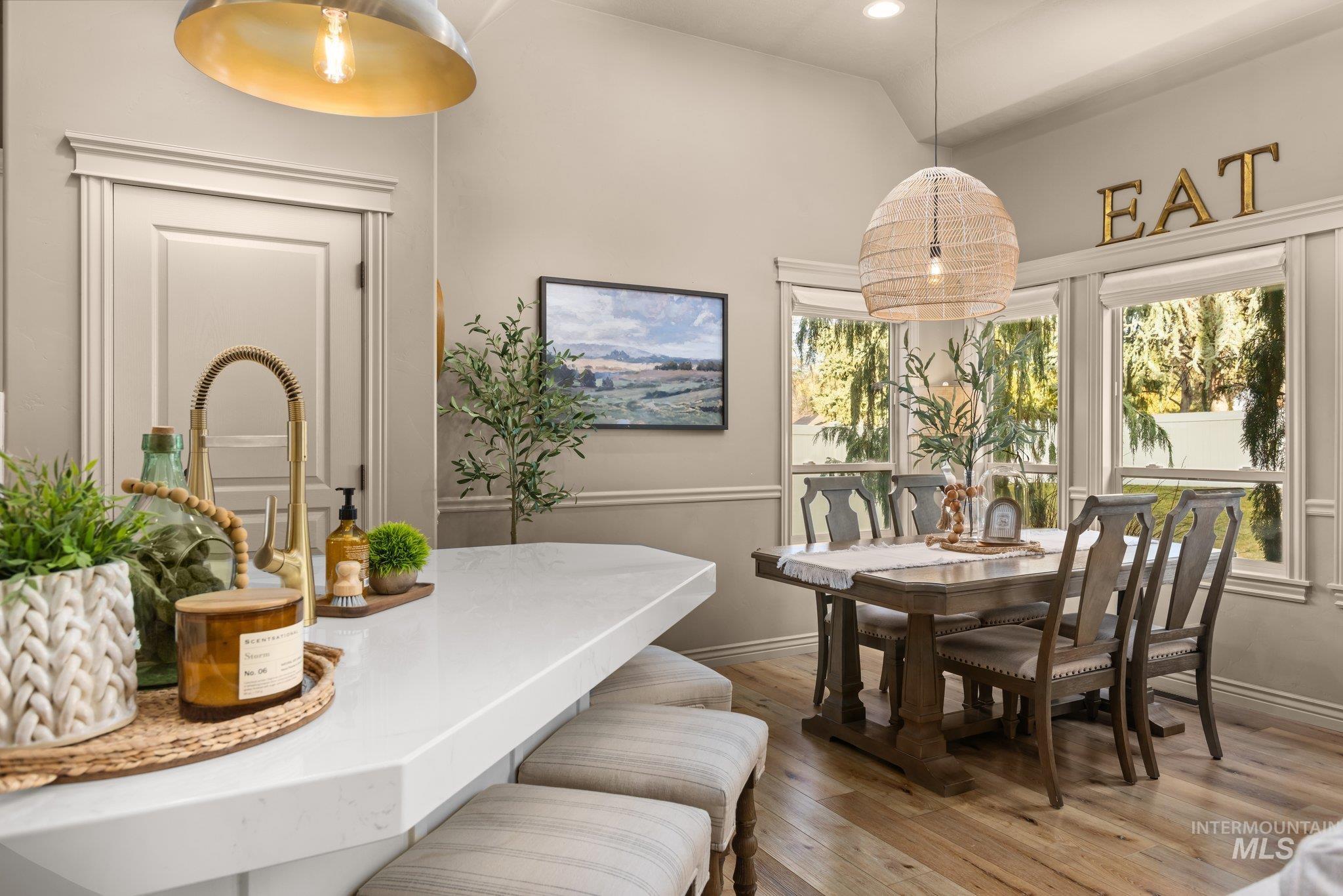 Dining room with light wood-style floors and lofted ceiling