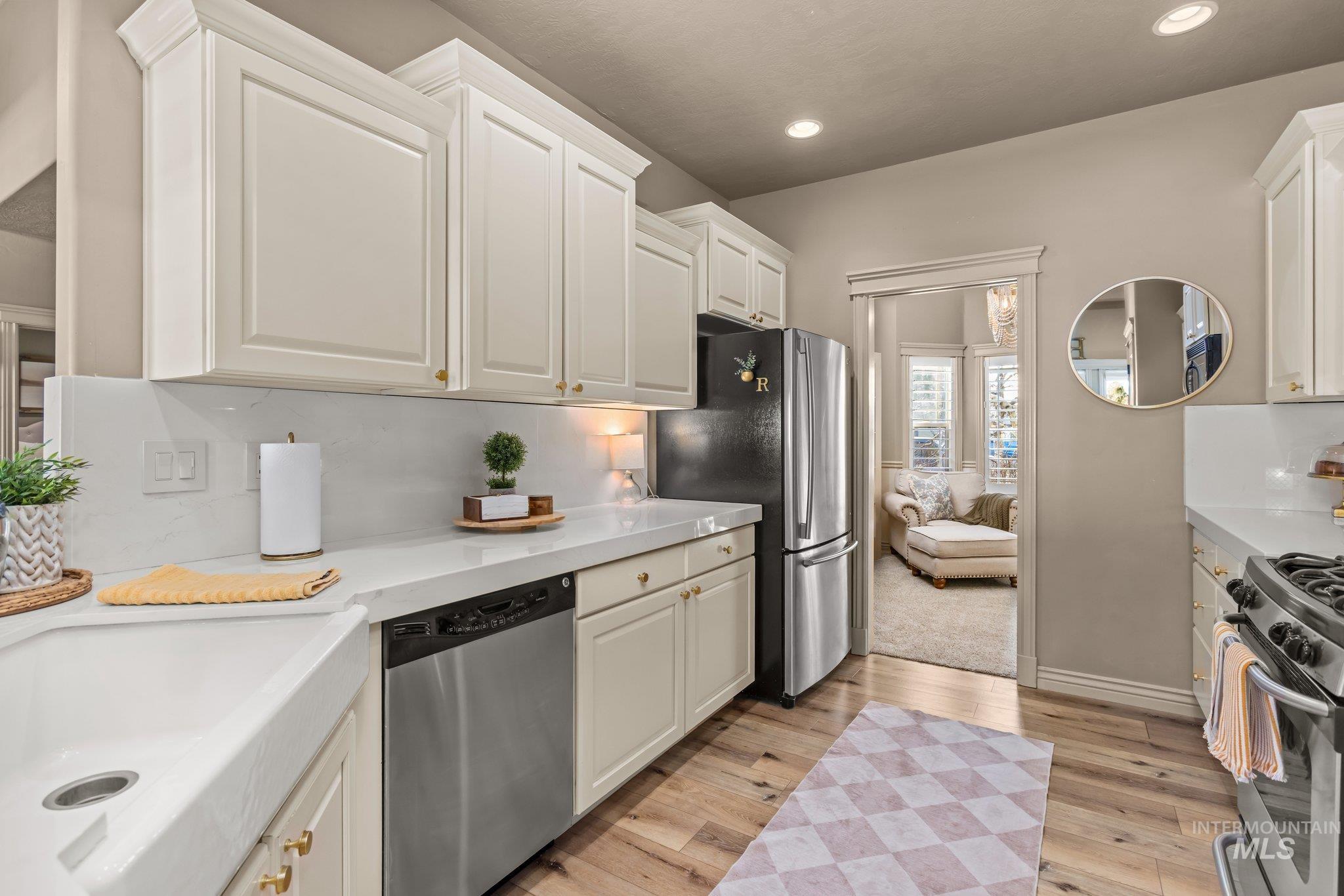 Kitchen featuring stainless steel appliances, light wood-style flooring, white cabinets, and recessed lighting