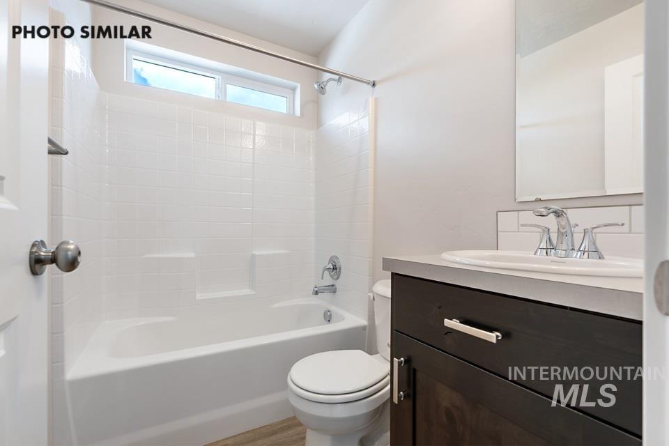 Full bath with vanity, shower / tub combination, and light wood-style flooring