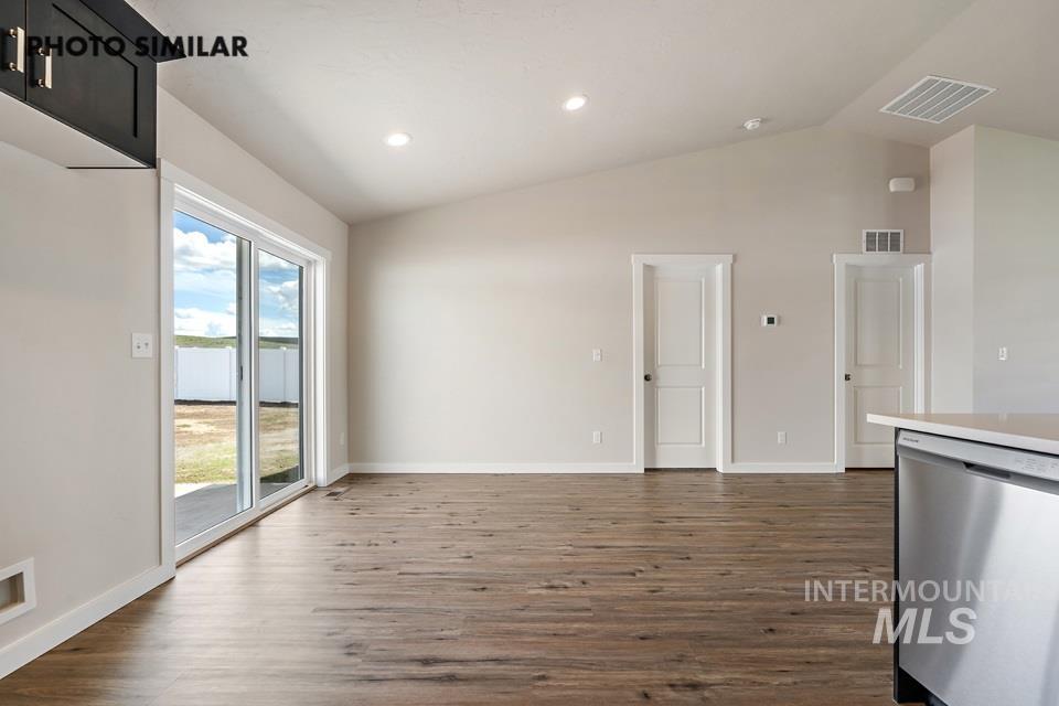 Unfurnished dining area with dark wood-type flooring, high vaulted ceiling, and recessed lighting
