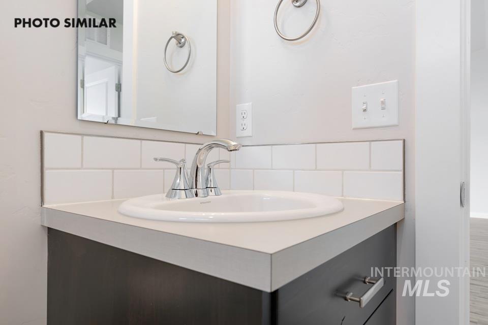 Bathroom with decorative backsplash and vanity