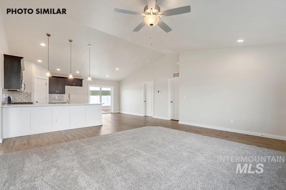Unfurnished living room featuring light wood-style flooring, recessed lighting, ceiling fan, and high vaulted ceiling