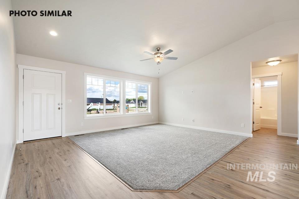 Entryway featuring vaulted ceiling, light wood finished floors, and ceiling fan