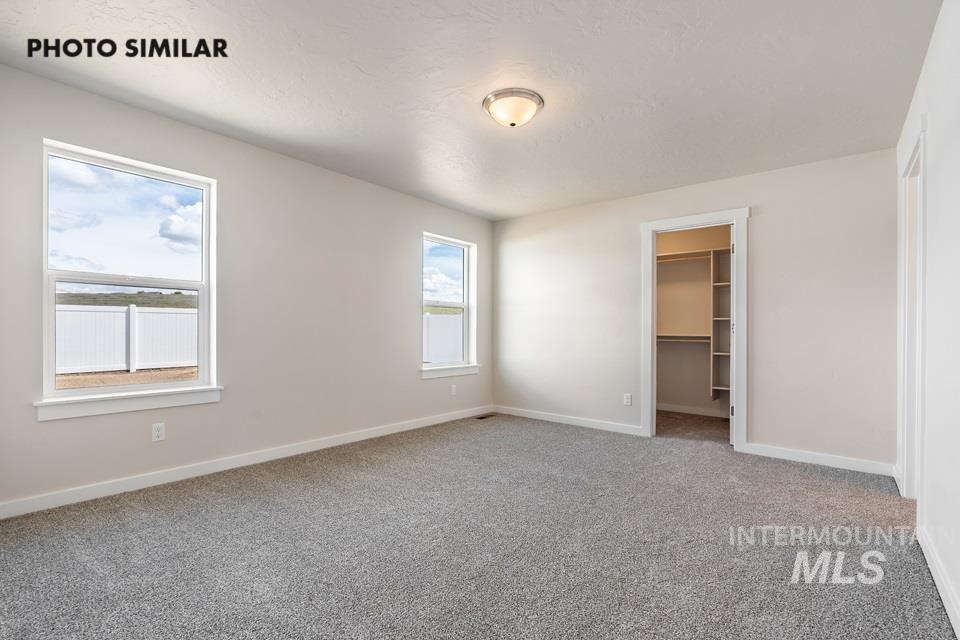 Unfurnished bedroom featuring a spacious closet and light carpet