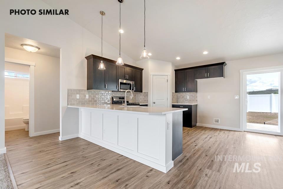 Kitchen featuring healthy amount of natural light, decorative backsplash, hanging light fixtures, and recessed lighting