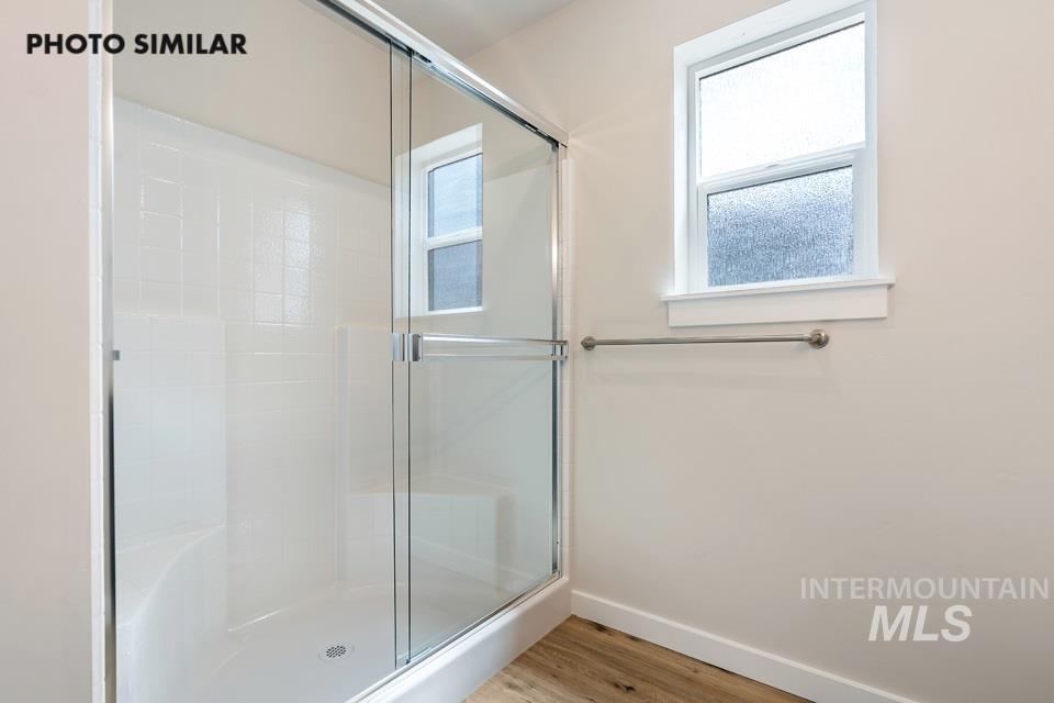 Bathroom with light wood-style floors and a shower stall