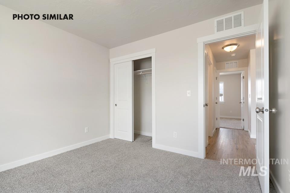Unfurnished bedroom with light carpet and a closet