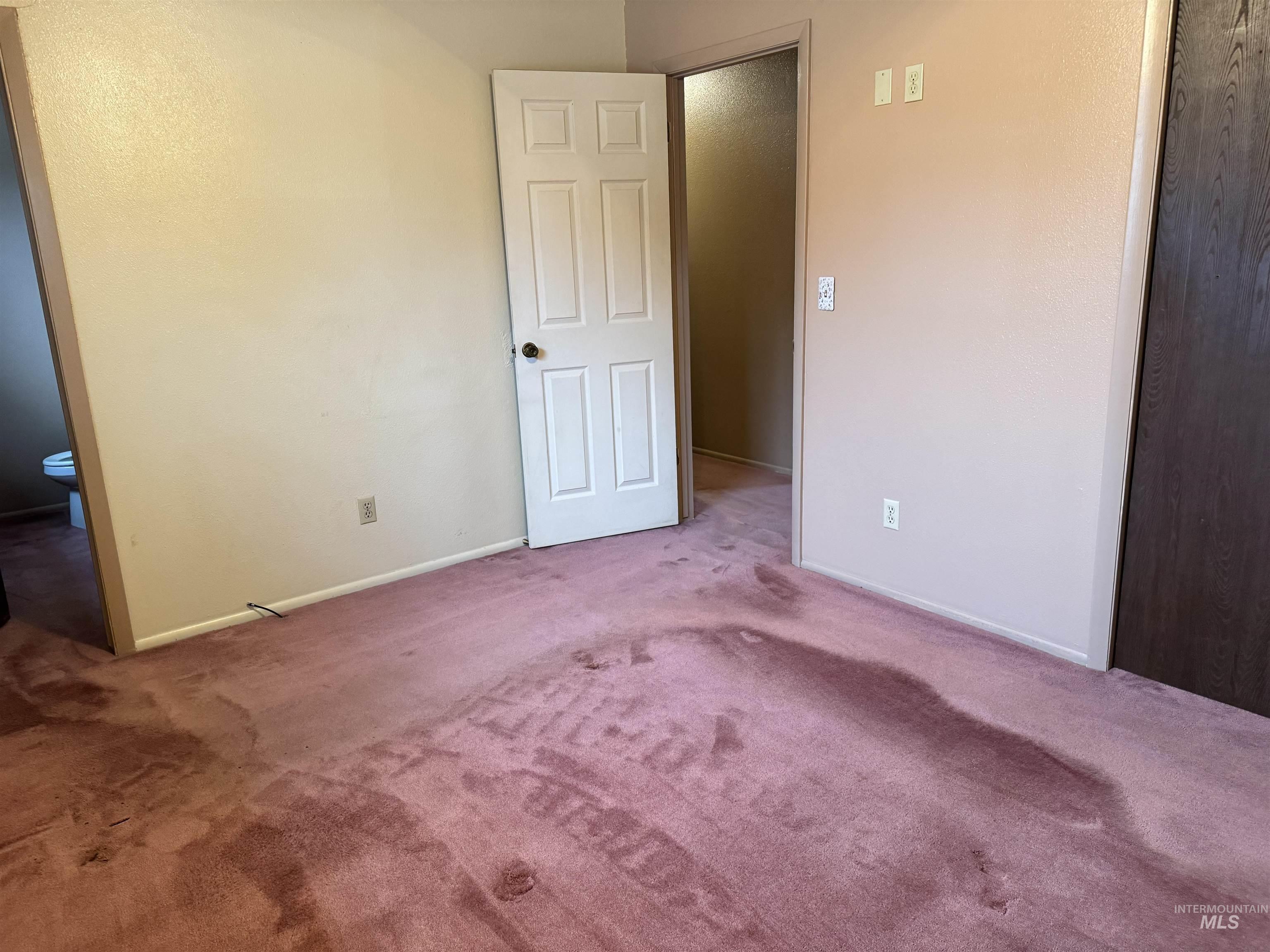 Unfurnished bedroom featuring carpet flooring and ensuite bathroom