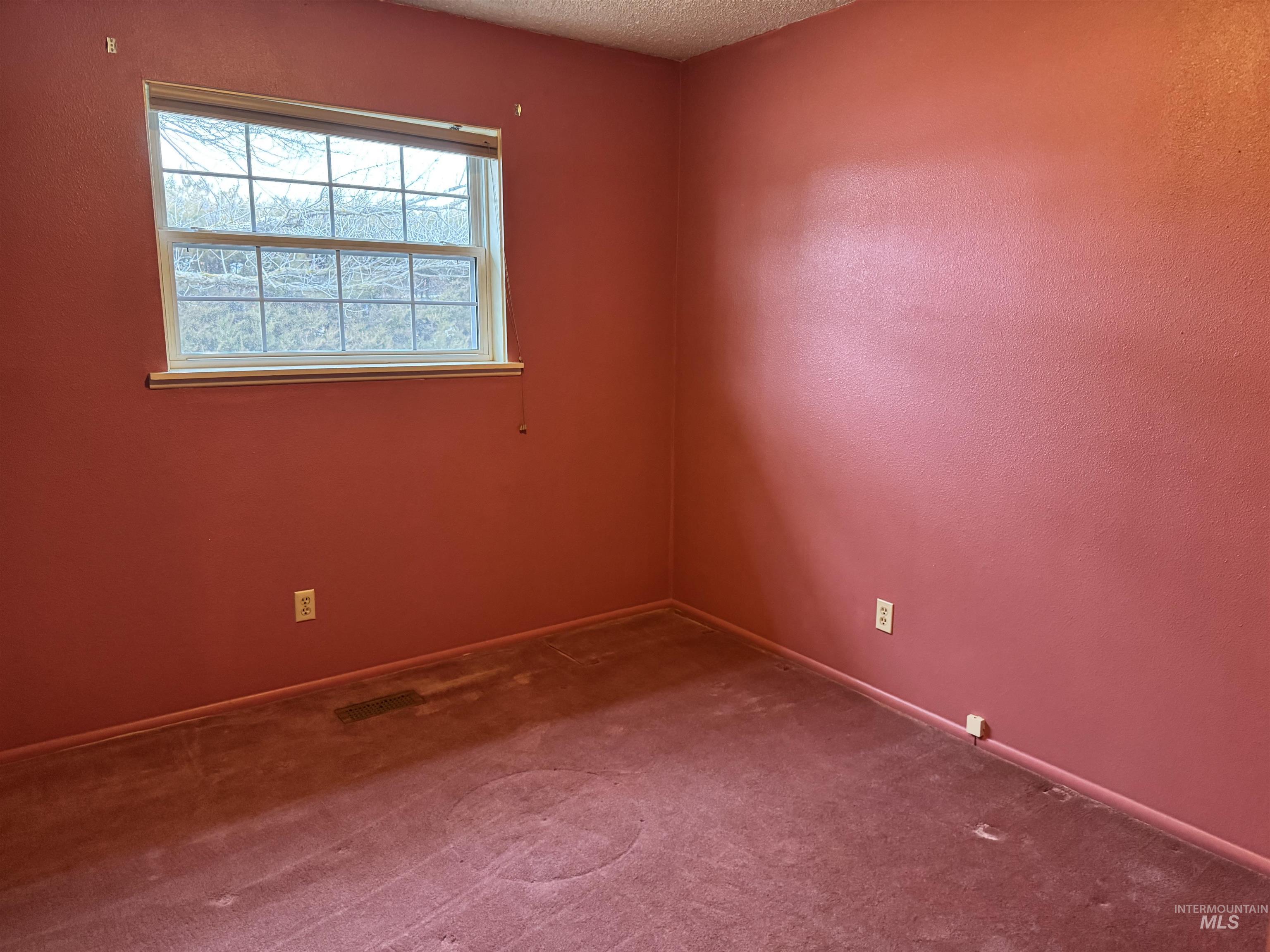 Empty room featuring carpet flooring and a textured ceiling