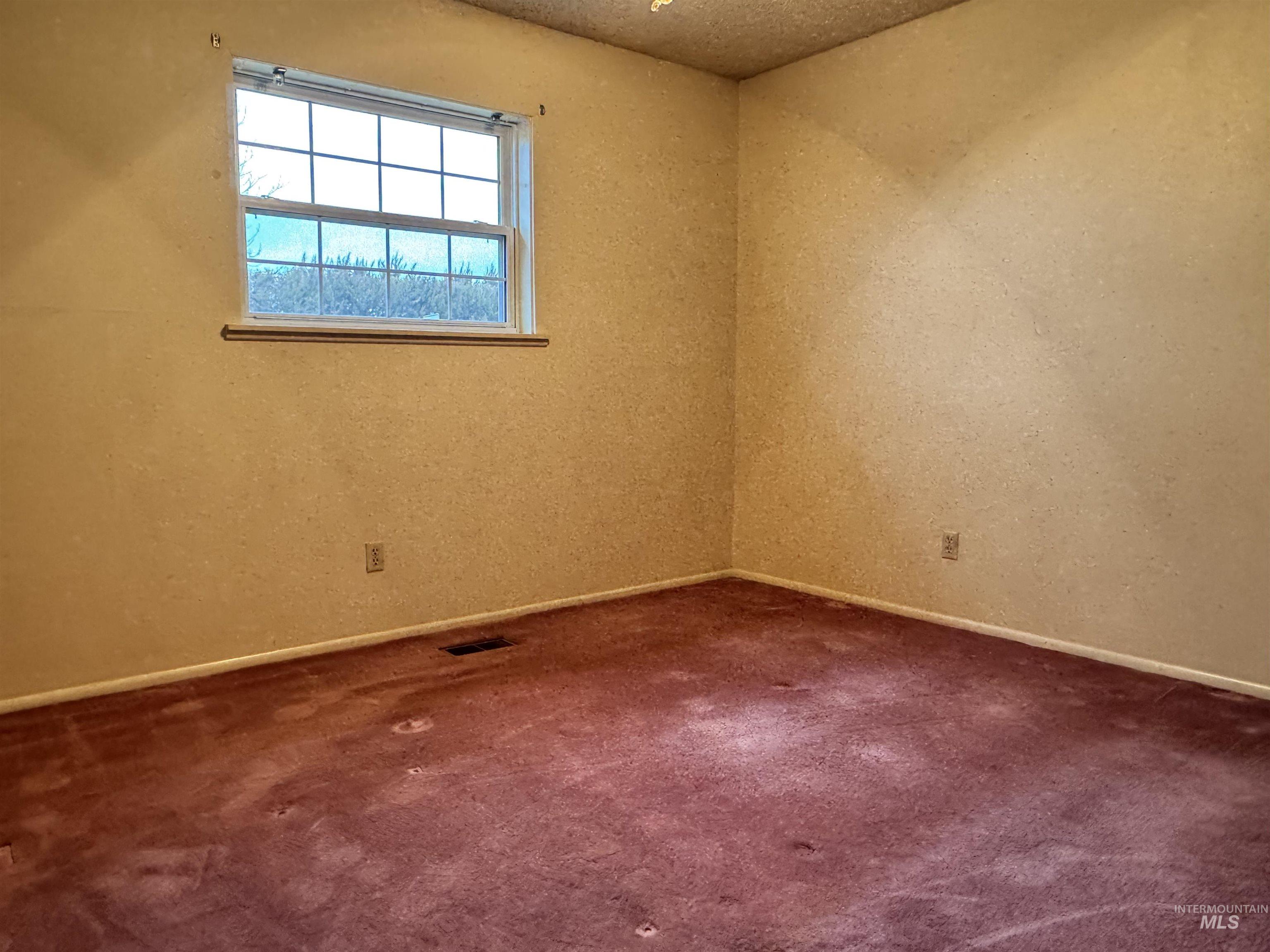 Spare room with a textured ceiling and dark carpet