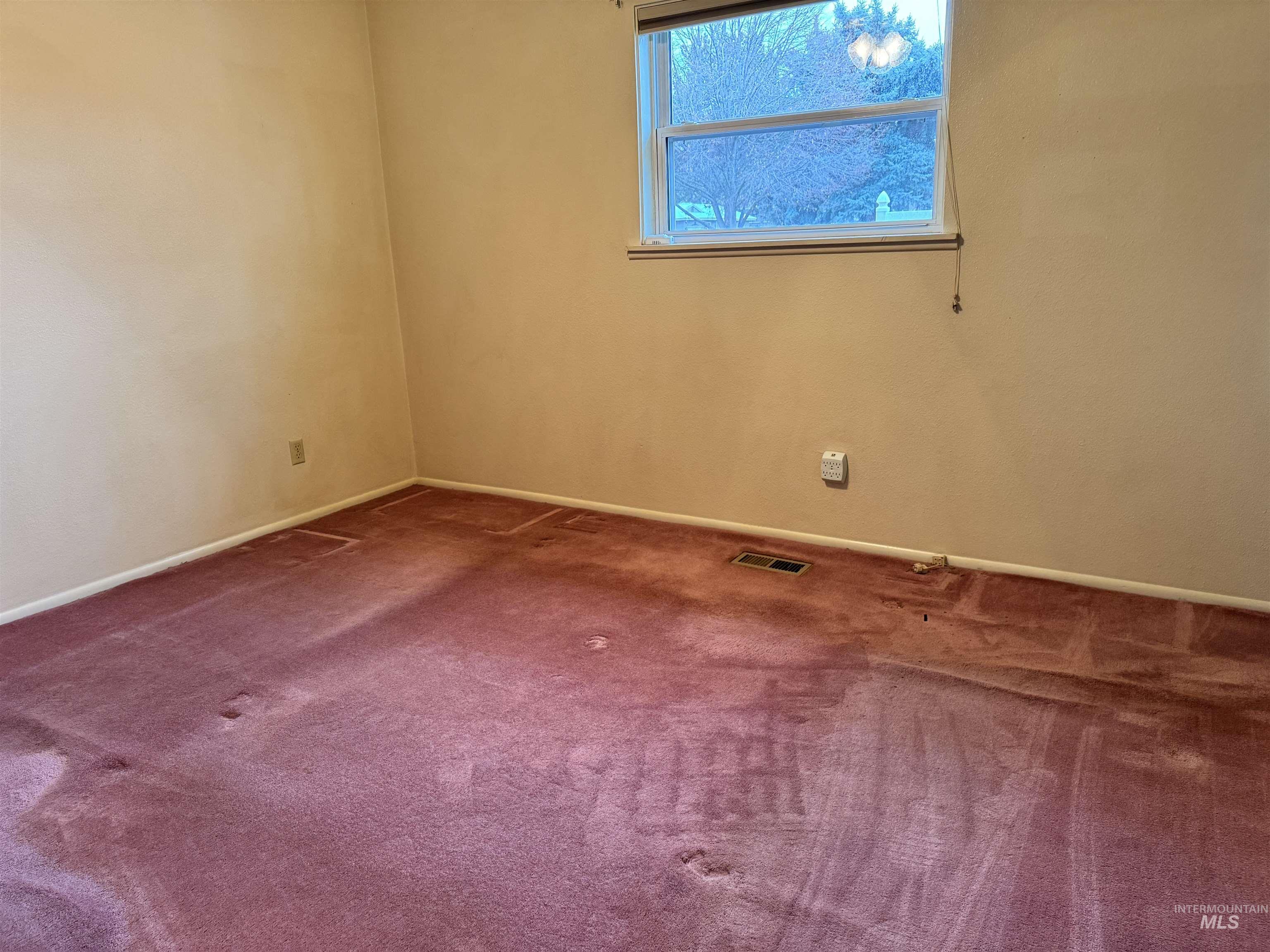 Empty room featuring carpet and baseboards