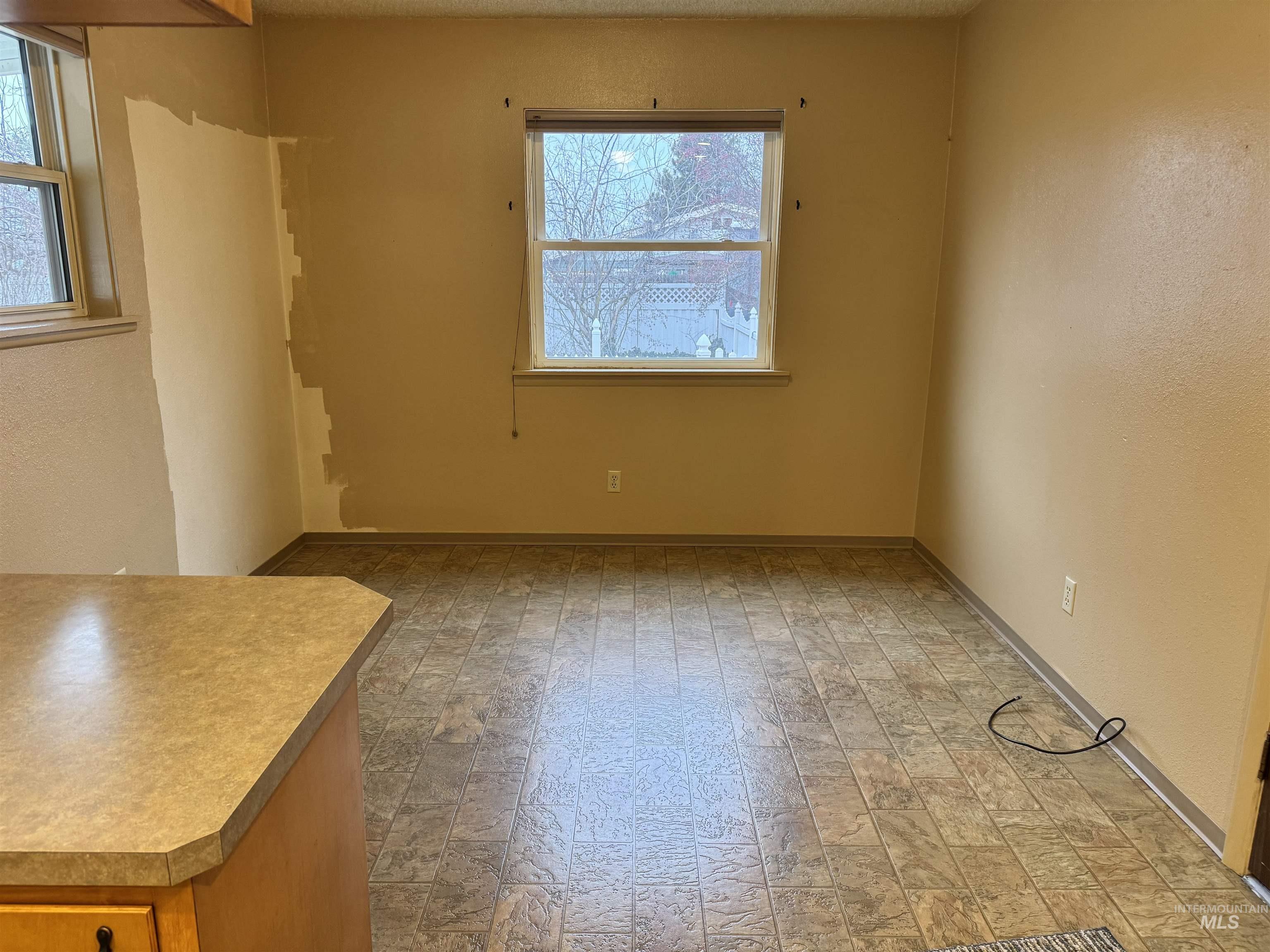 Unfurnished dining area with healthy amount of natural light and a textured wall