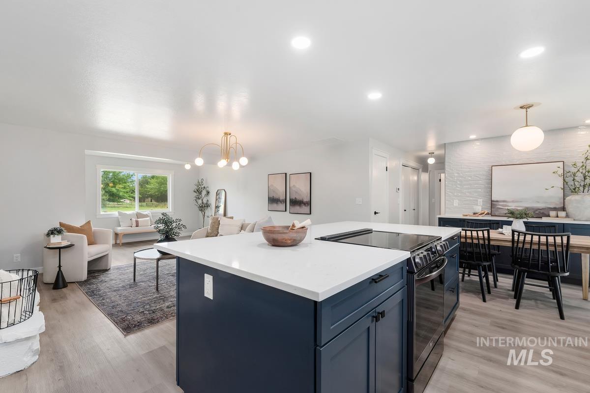 Kitchen featuring open floor plan, electric range, light wood finished floors, and recessed lighting