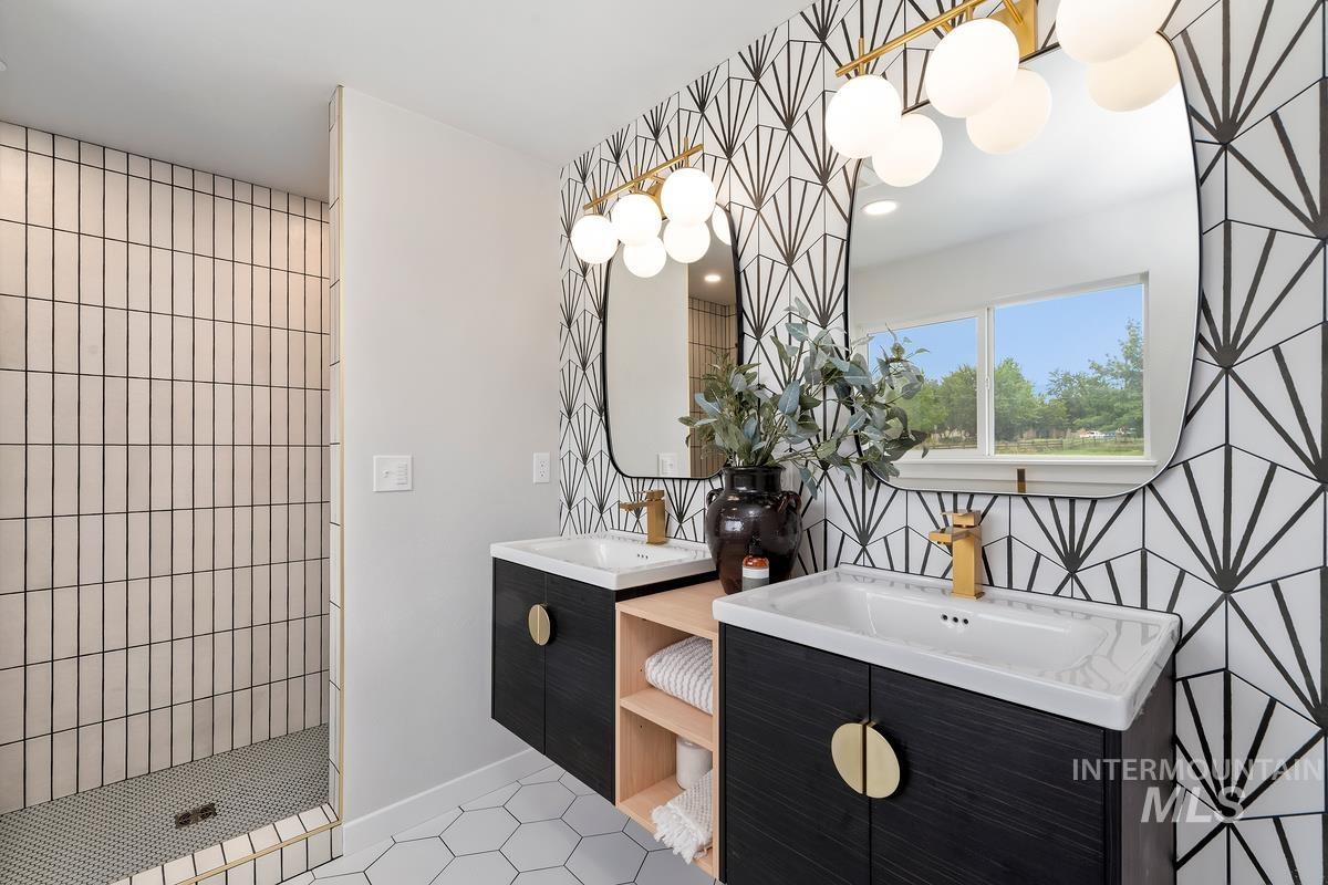 Bathroom with tile patterned floors, two vanities, and tiled shower