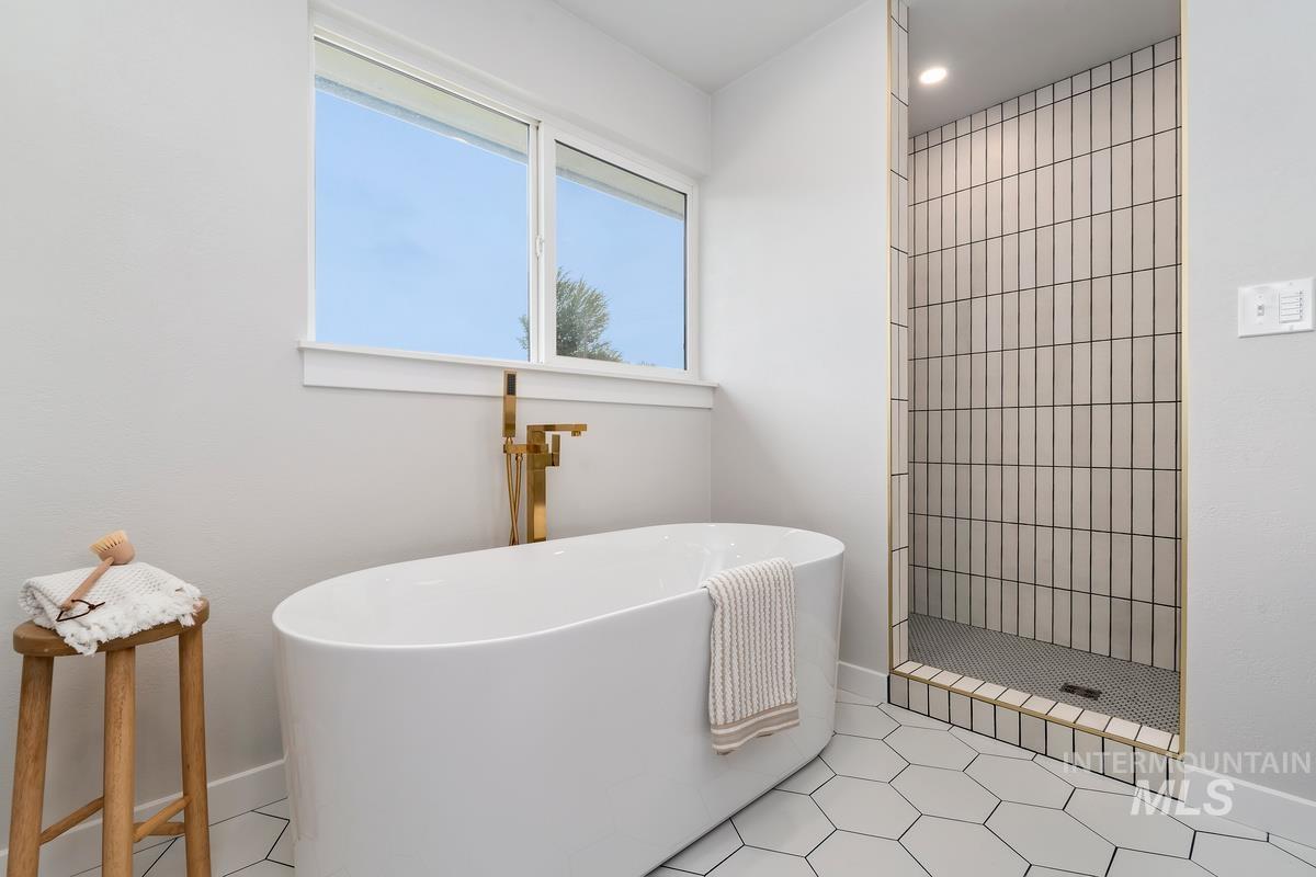 Full bathroom with a freestanding bath, tiled shower, and recessed lighting