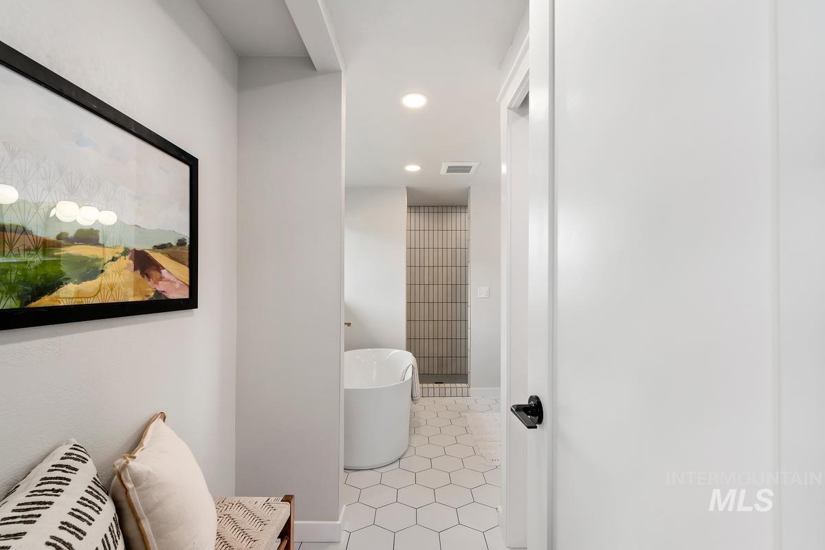 Bathroom featuring a soaking tub, recessed lighting, and tile patterned floors