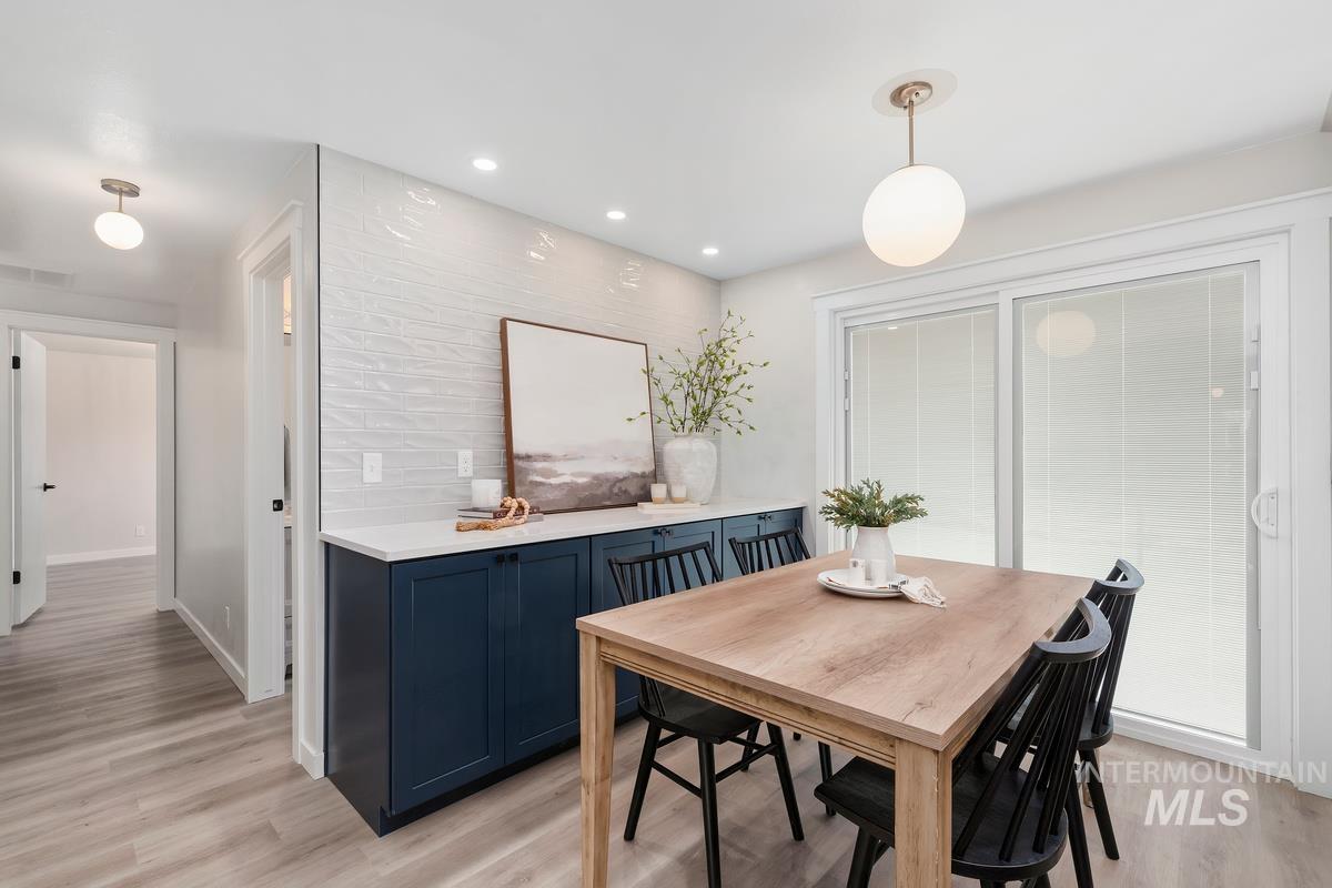 Dining room with light wood-style floors and recessed lighting