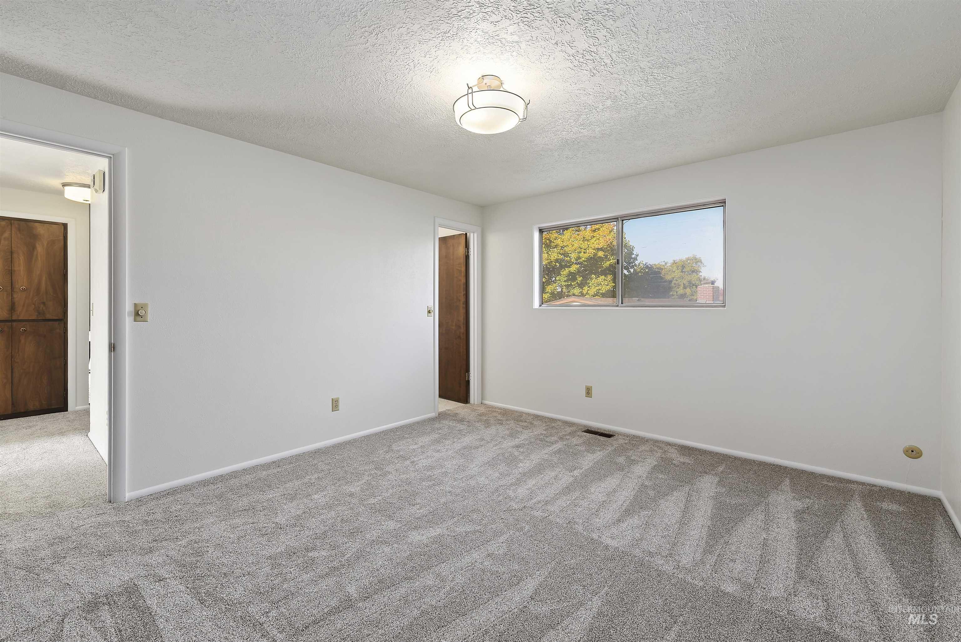 Unfurnished bedroom featuring carpet flooring and a textured ceiling