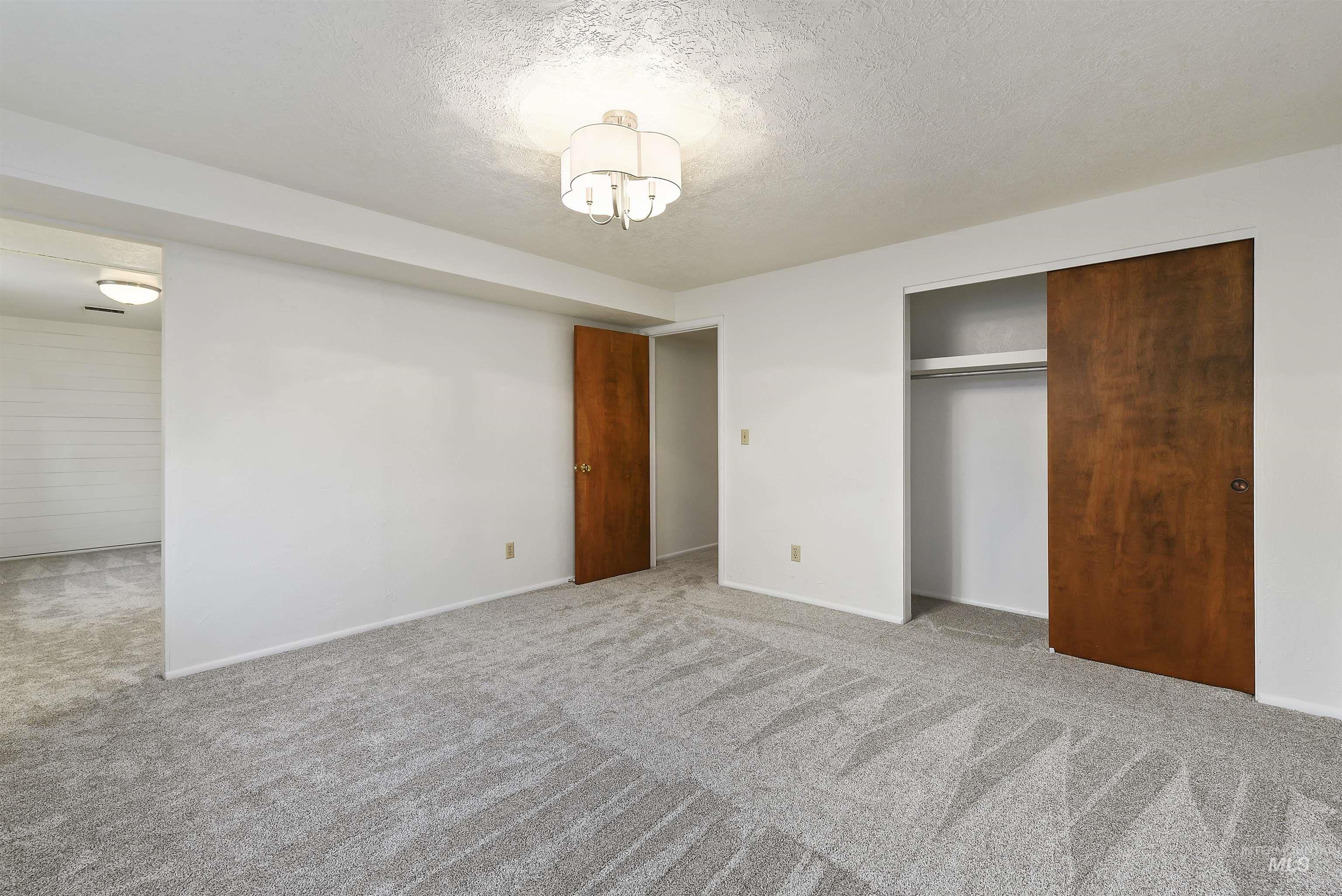 Unfurnished bedroom featuring a textured ceiling, carpet floors, and a closet