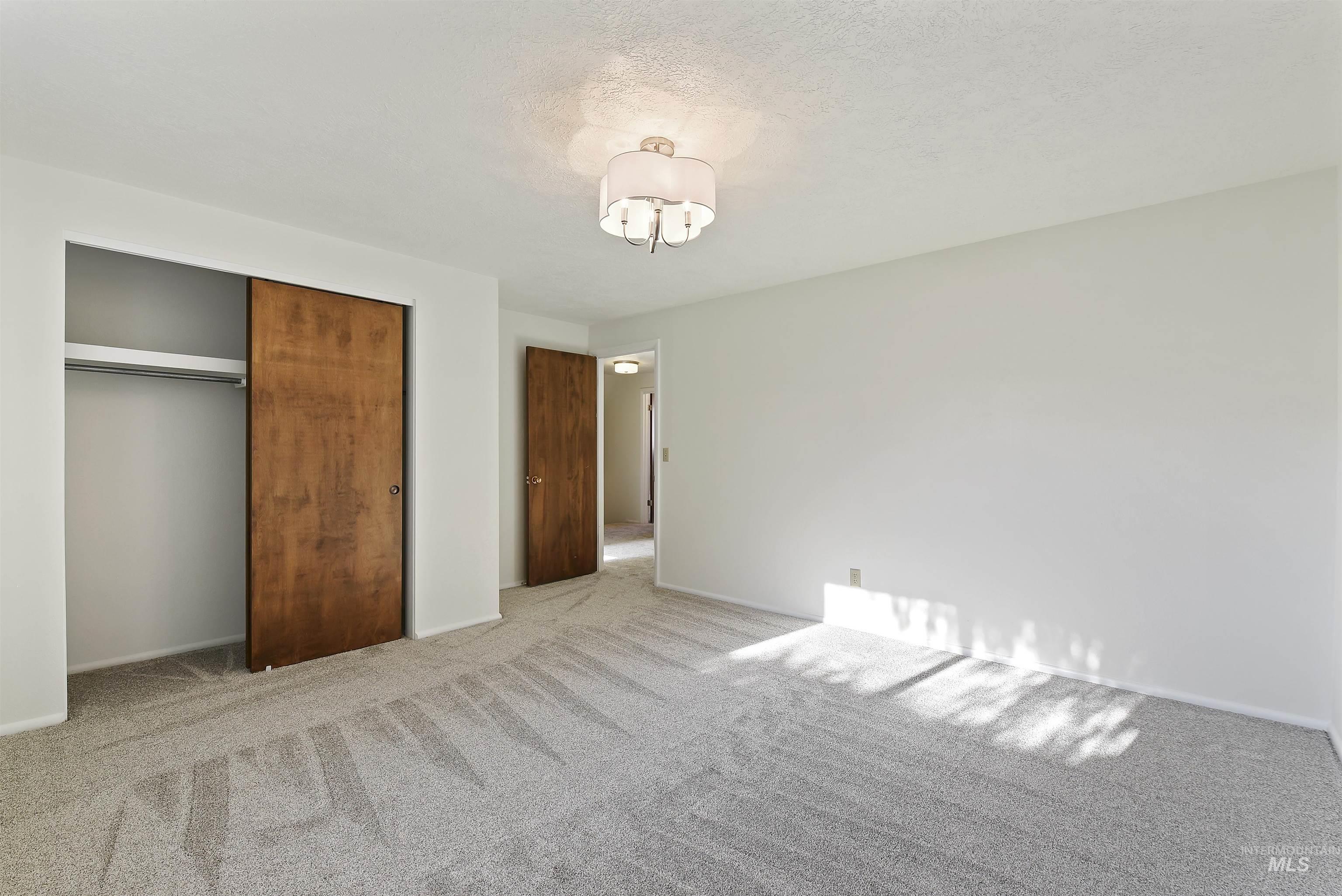 Unfurnished bedroom with carpet floors, a closet, and a textured ceiling