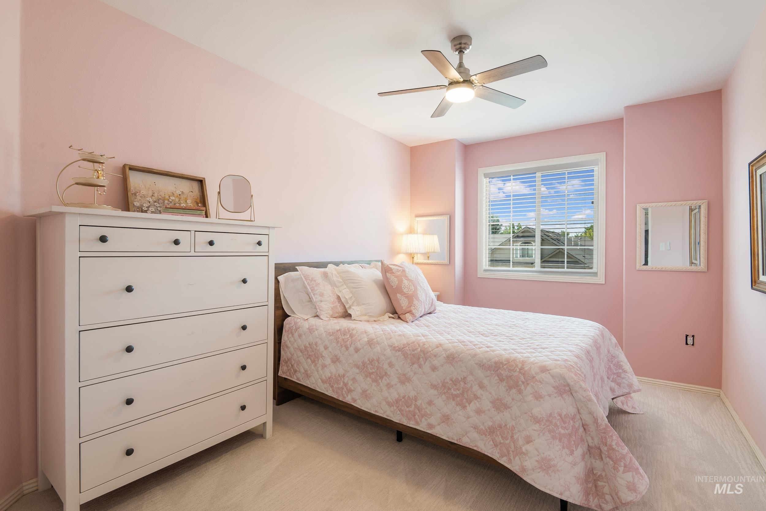 Bedroom with light colored carpet and ceiling fan