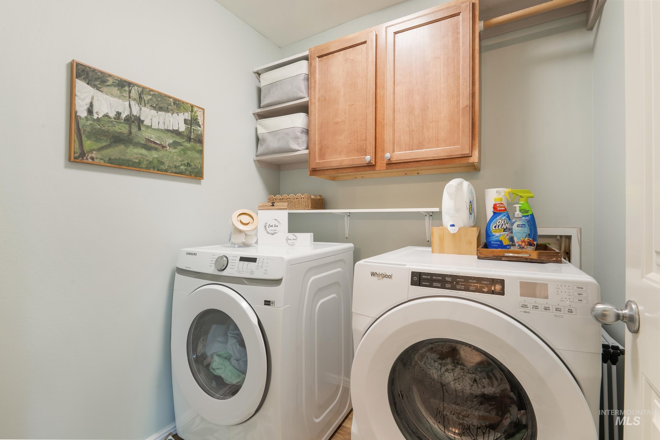 Laundry room featuring separate washer and dryer and cabinet space