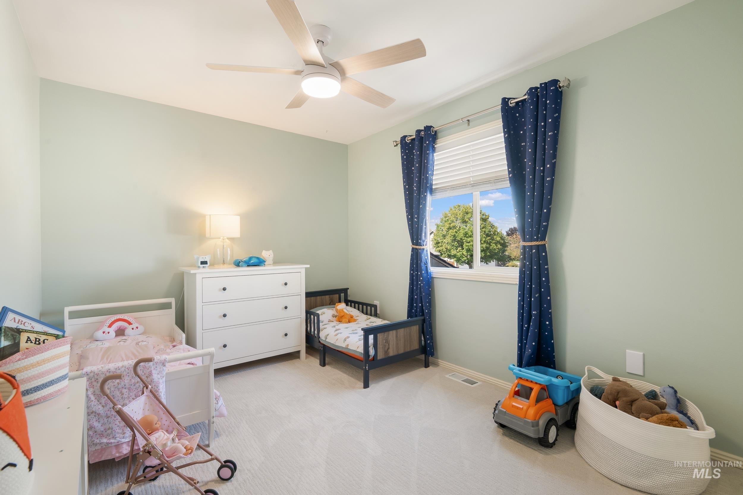 Bedroom featuring light carpet and ceiling fan