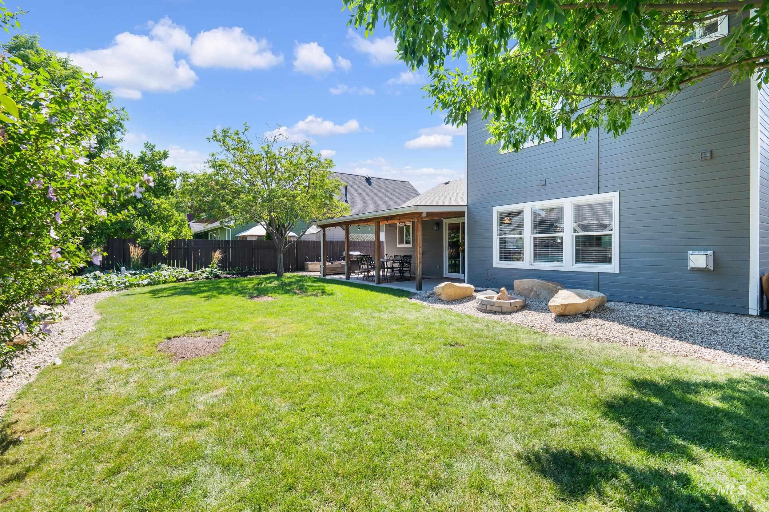 Fenced backyard featuring a patio area and a fire pit
