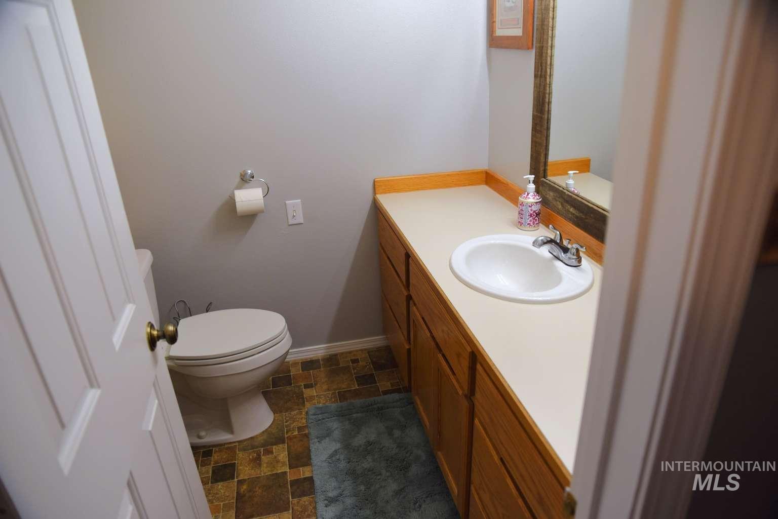Half bath with stone finish floors and vanity