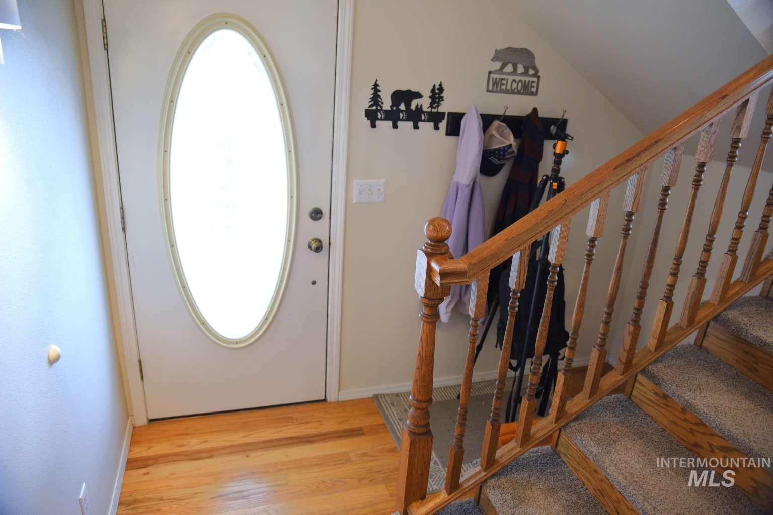 Foyer featuring light wood-type flooring and lofted ceiling