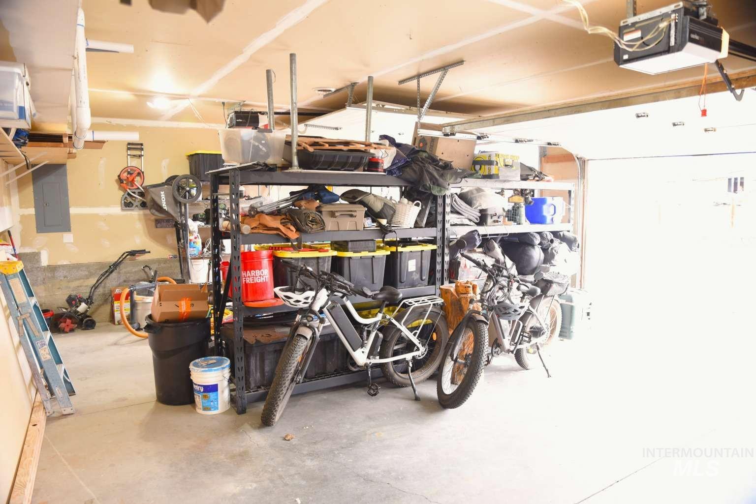 Garage featuring a garage door opener and electric panel