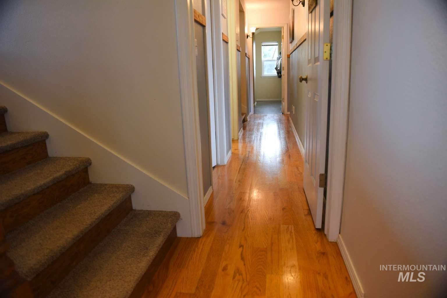 Corridor featuring stairway and light wood-style floors