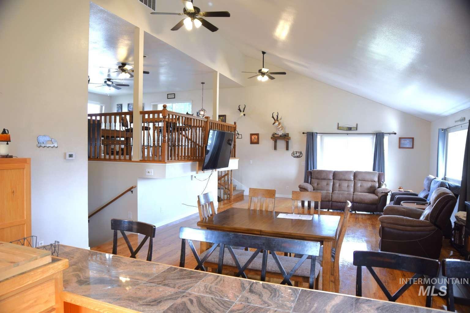 Dining room featuring wood finished floors, lofted ceiling, and ceiling fan