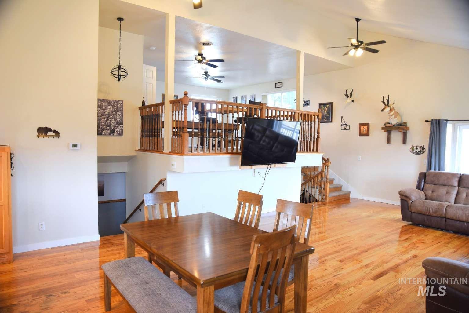 Dining area featuring light wood-style floors, a ceiling fan, and lofted ceiling