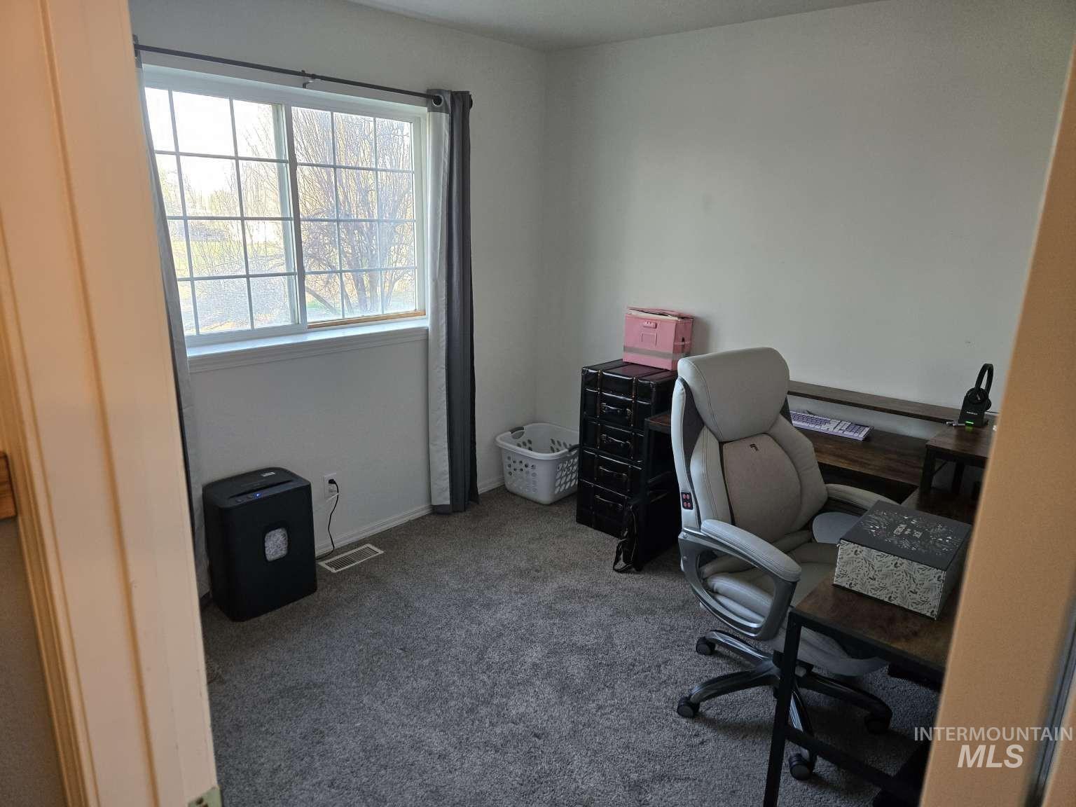 Office featuring dark colored carpet and baseboards