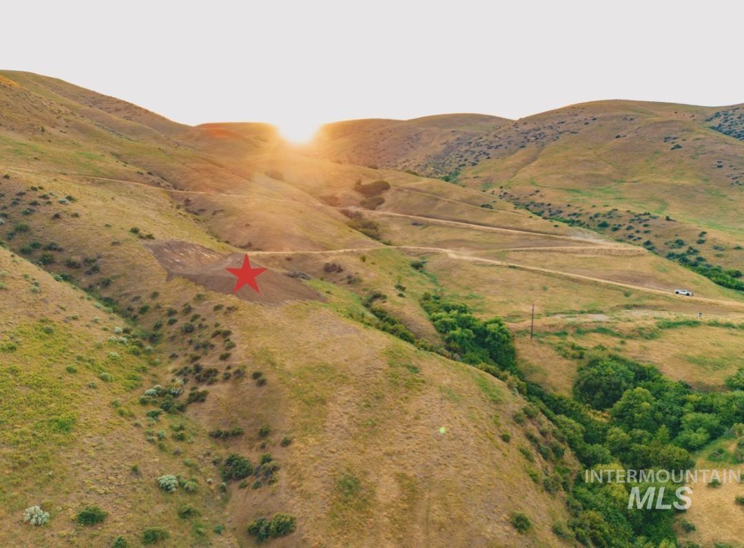 Aerial view of property and surrounding area featuring a mountainous background and rural landscape