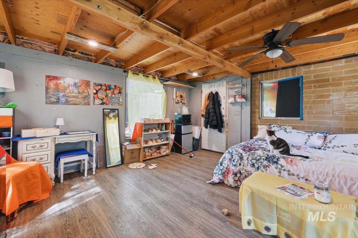Finished space featuring exposed wood ceiling joists and wood-finish flooring