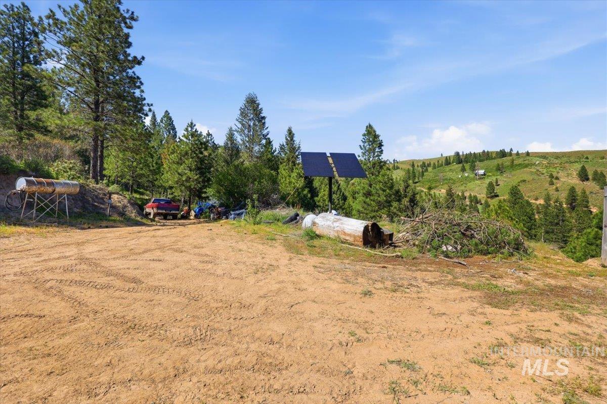 Expansive cleared lot with an integrated solar panel system and distant rolling hills