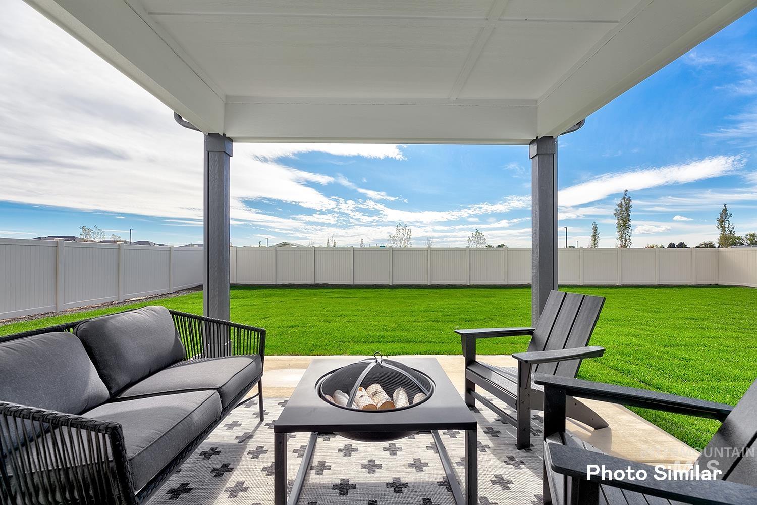 Fenced backyard featuring a patio area and a fire pit