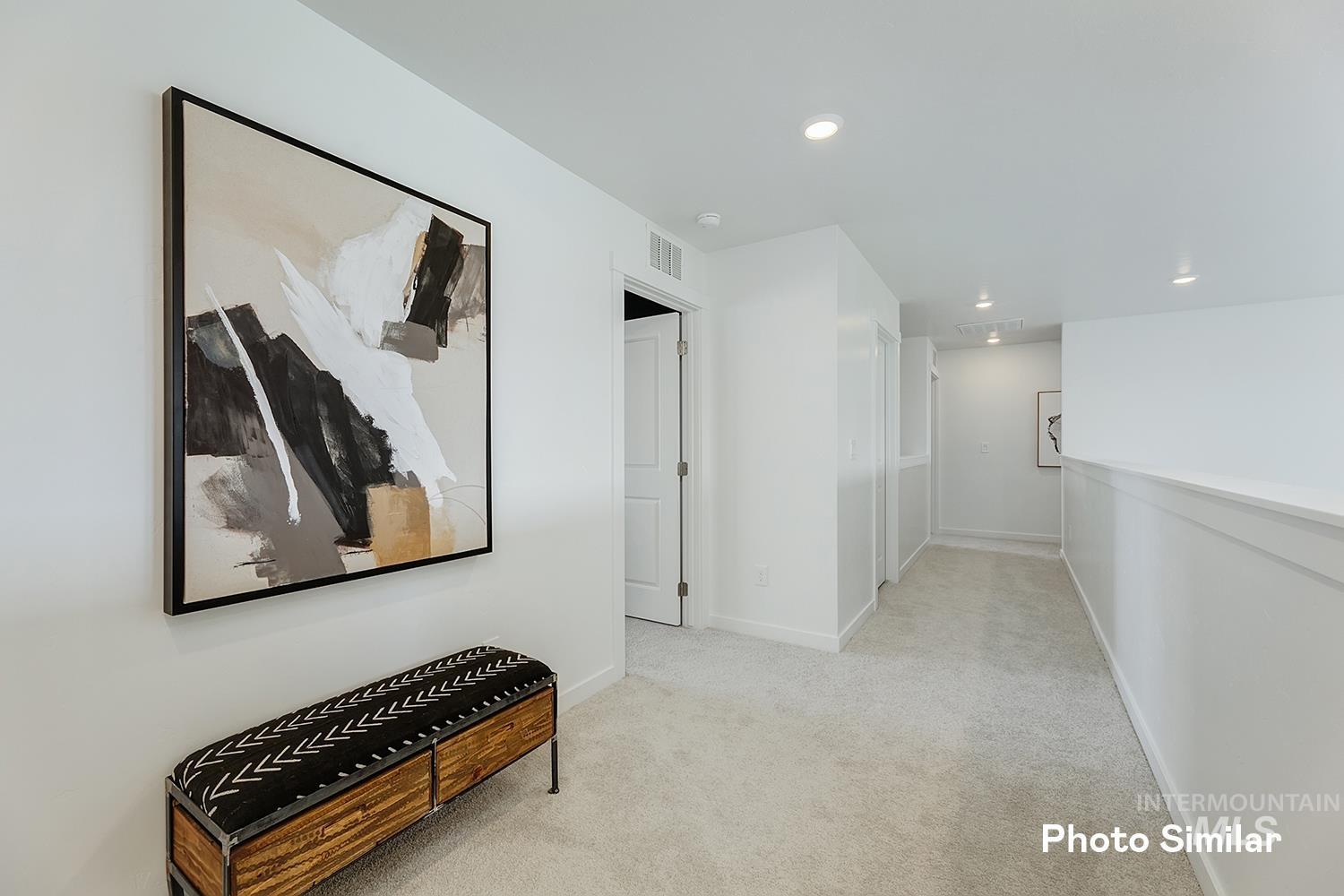 Hallway with light carpet and recessed lighting