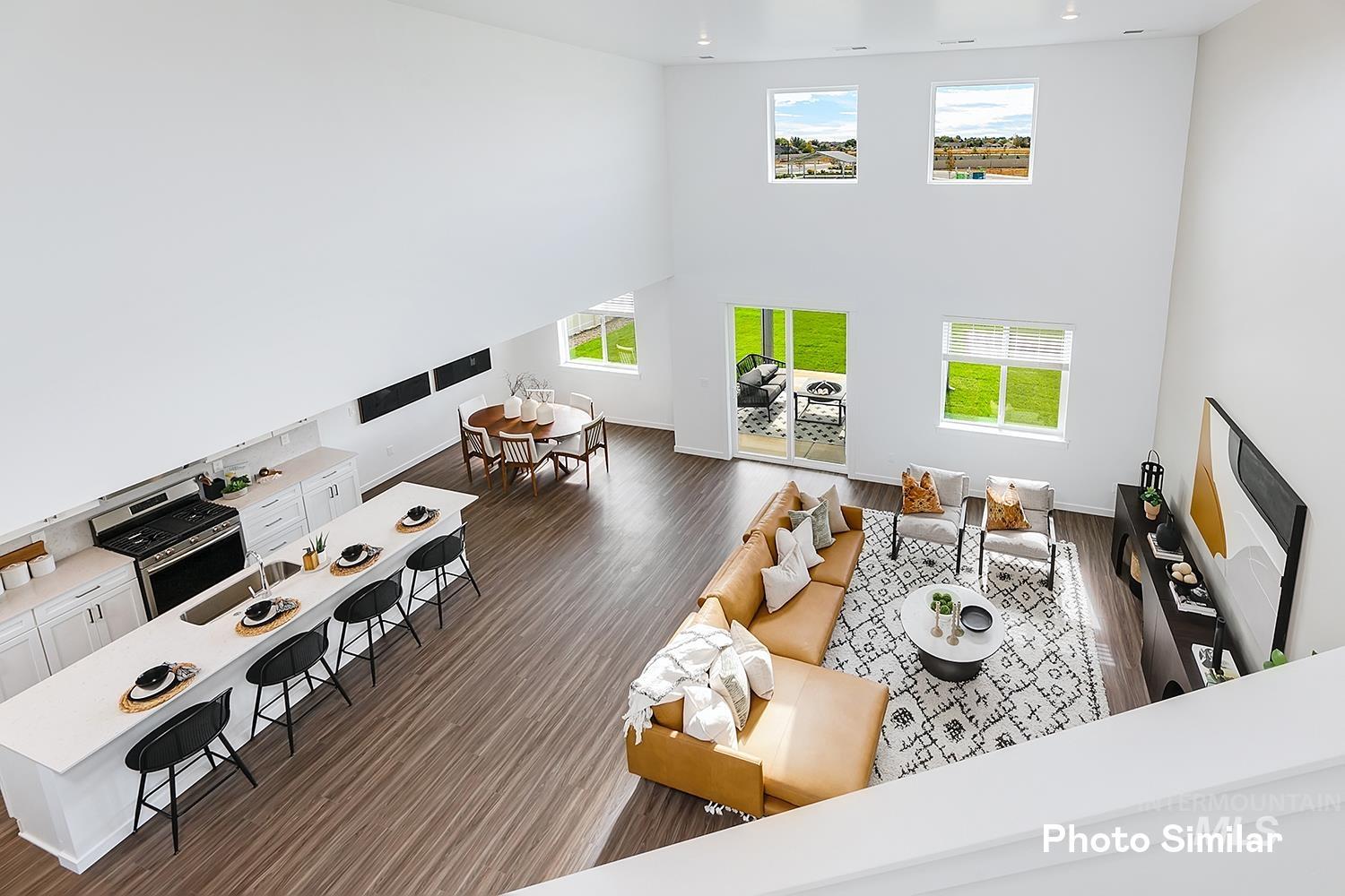 Living area featuring a towering ceiling and dark wood-style flooring