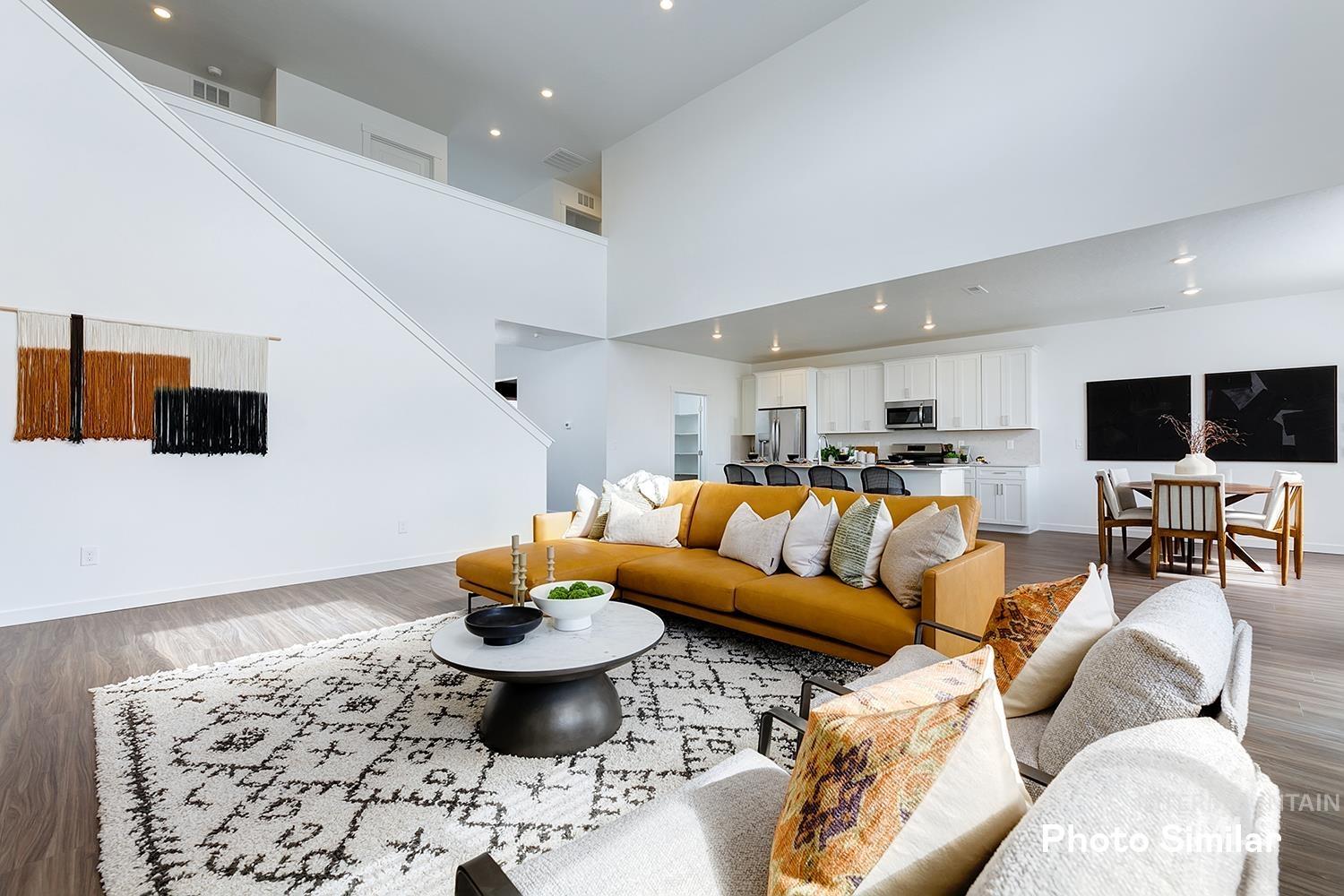 Living room featuring wood finished floors, recessed lighting, and a towering ceiling