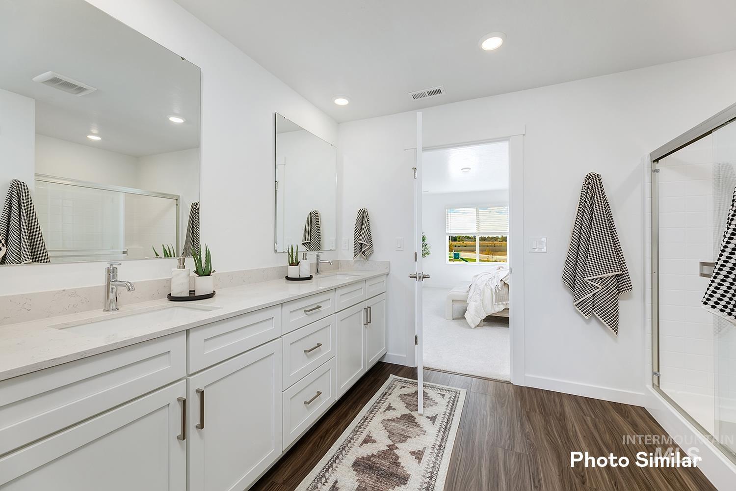 Full bath with a stall shower, double vanity, dark wood-style flooring, recessed lighting, and ensuite bath