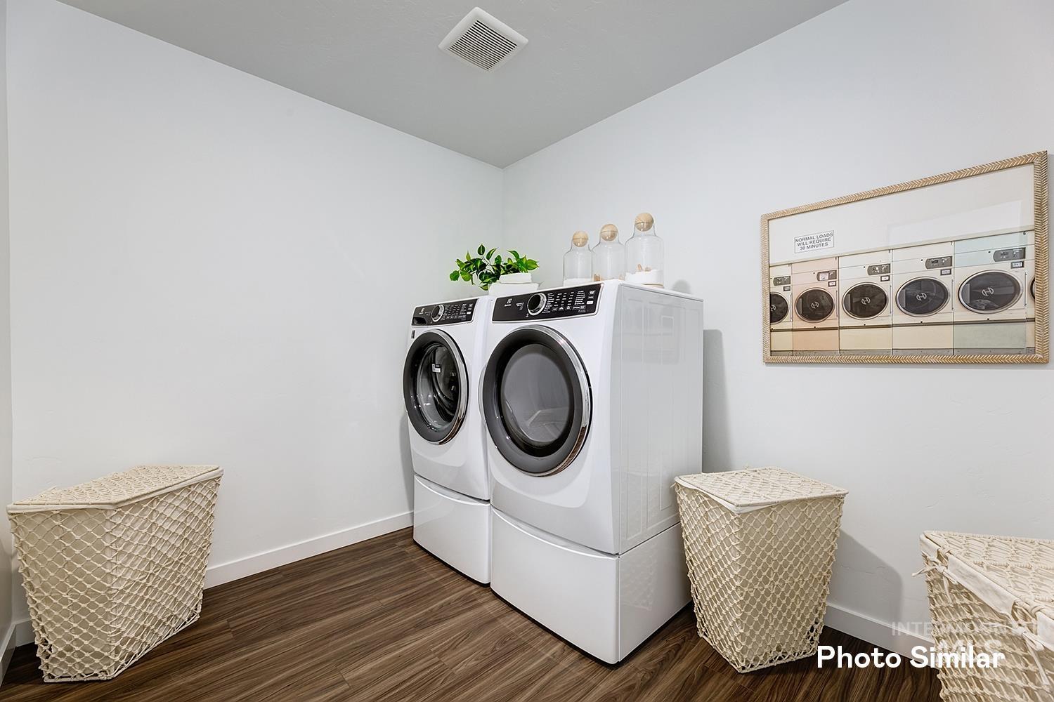 Laundry area with dark wood-type flooring and independent washer and dryer