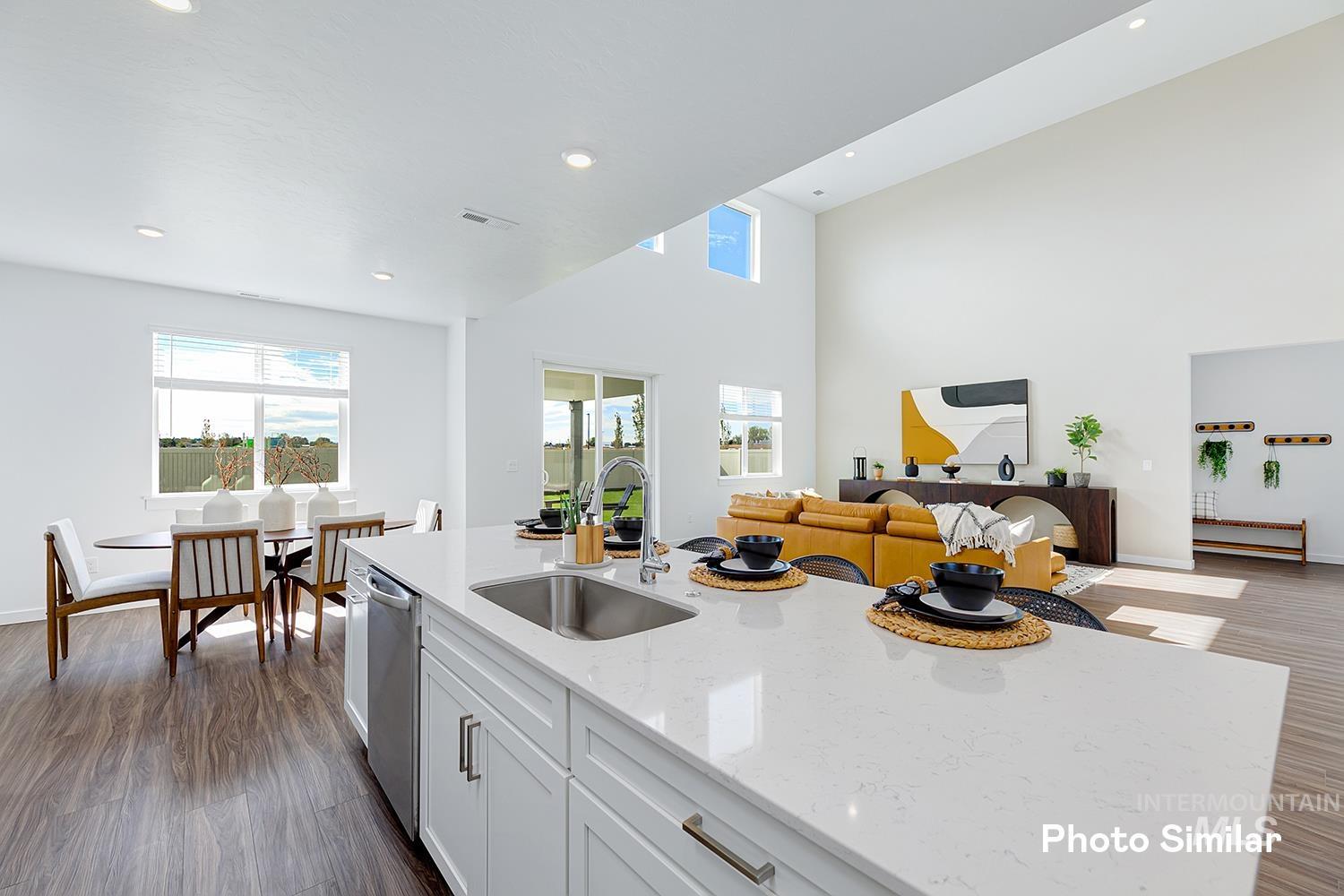 Kitchen with dark wood-type flooring, light stone counters, white cabinetry, recessed lighting, and open floor plan