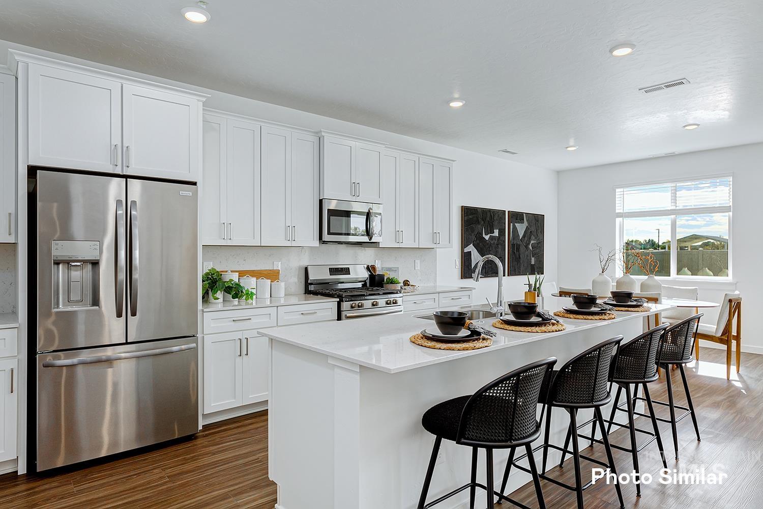 Kitchen with appliances with stainless steel finishes, white cabinetry, a kitchen island with sink, dark wood-style flooring, and recessed lighting