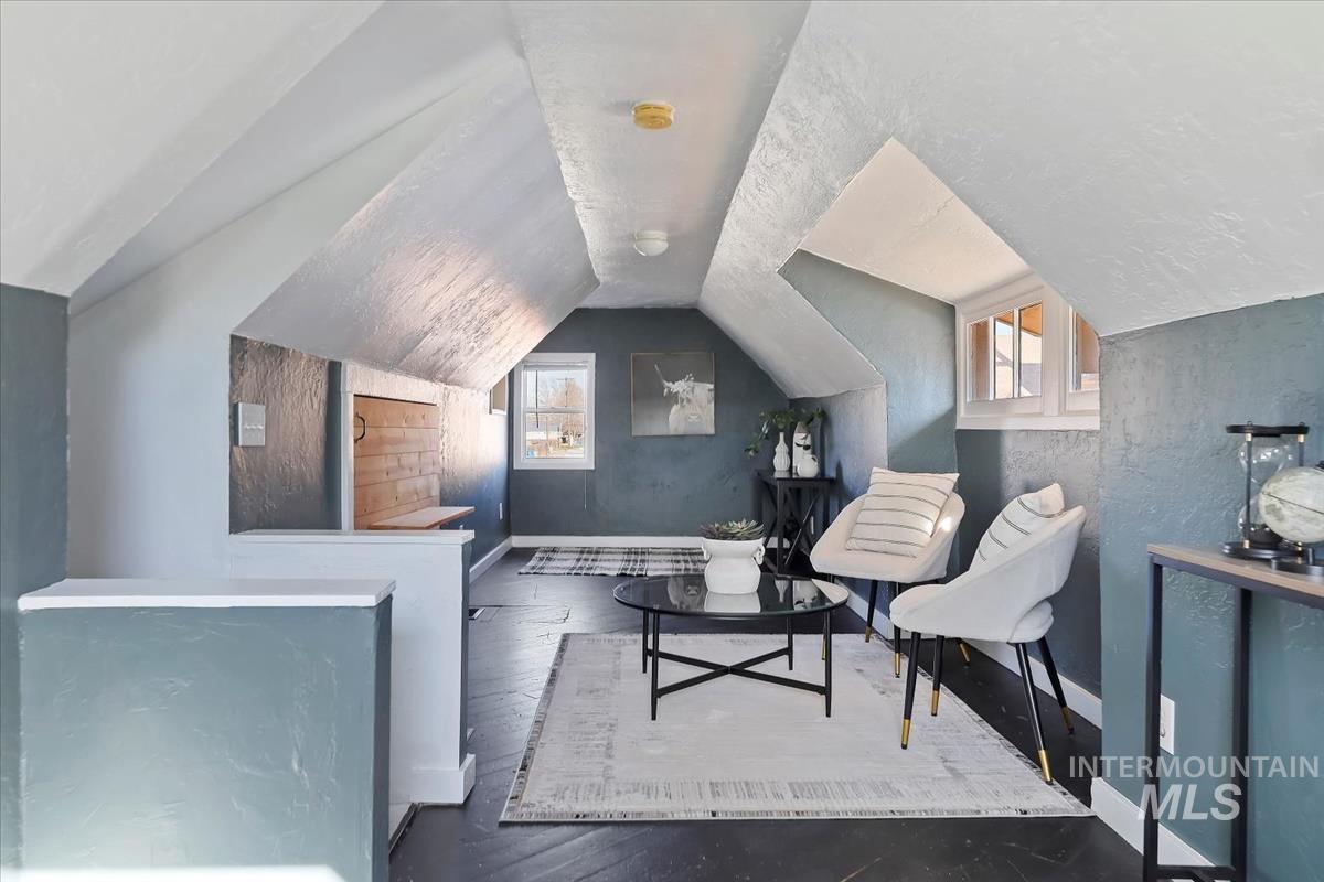 Sitting room featuring vaulted ceiling and hardwood / wood-style floors